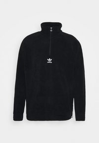 Svart fleece-tröja med hög krage, halvlång dragkedja fram och vit Adidas-logotyp på bröstet. Har raglanärmar och texturerat tyg.