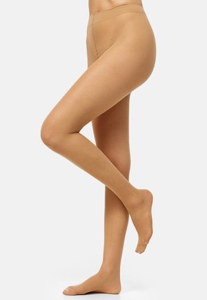 Piernas con medias transparentes color nude, un pie apoyado plano en el suelo y el otro levantado con los dedos apuntando.