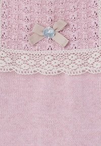 Un capo lavorato a maglia rosa chiaro presenta un bordo in pizzo, un corpo testurizzato e un accento in beige con un fiocco e un bottone argento al centro.