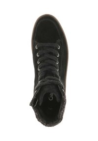 Zwarte hoge sneaker met zwarte veters, metalen oogjes, bovenwerk van suede, gevoerde kraag met bont en zijrits op een witte achtergrond.