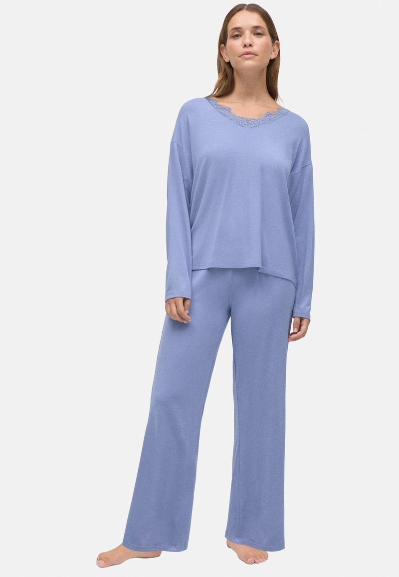 Conjunto de pijama color azul claro con mangas largas y pantalones de pierna ancha, con un borde de encaje en el escote y una textura de tela suave y lisa.