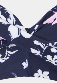Marineblauer Stoff mit einem floralen Muster in Weiß und zartem Rosa; zeichnet sich durch ein gedrehtes Design mit glatter Textur und weichem Finish aus.
