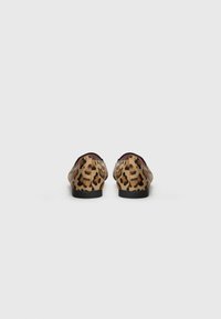 Mocassins de estampado de leopardo com uma superfície texturizada, sola preta e bico redondo; apresentam um discreto detalhe vermelho no calcanhar.
