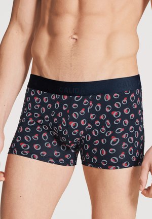 Fitted navy Boxer-Shorts mit einem kreisförmigen rot-grauen Muster, ausgestattet mit einem schwarzen elastischen Bund, der mit "CALIDA" gebrandet ist. Weicher Stoff.