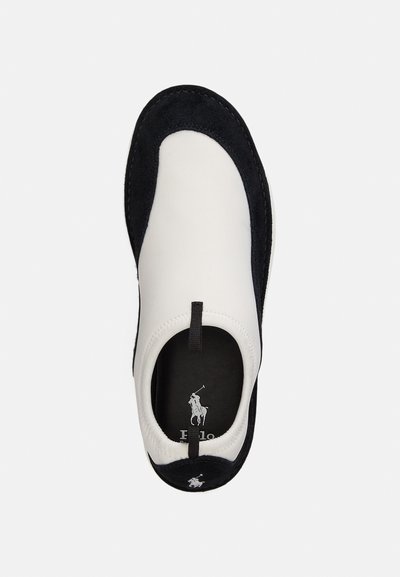 Παπούτσια slip-on με μαύρη σουέτ επένδυση και λευκό δέρμα στην επάνω πλευρά. Διαθέτουν υφασμάτινη θηλιά για εύκολη χρήση και μαύρη εσωτερική σόλα με λογότυπο.