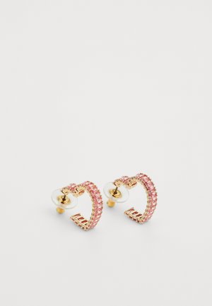 Auksinės spalvos žiedinės auskarai su rožinėmis dervos akmenimis, turintys struktūruotą paviršių ir skaidrų gumos pagrindą saugiam nešiojimui.