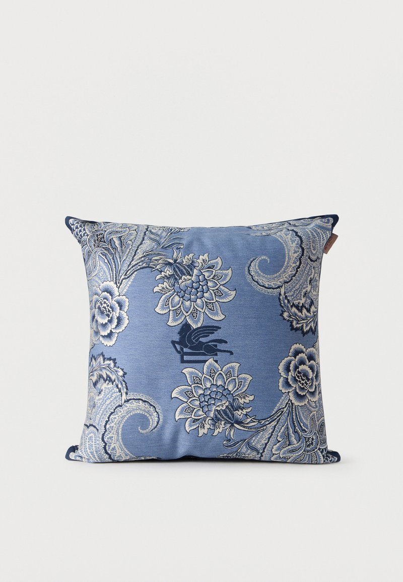 Coussin carré bleu avec motifs floraux et paisley ornés blancs et bleu marine sur fond uni.