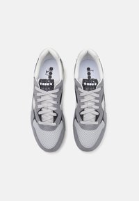 Scarpe sportive grigie in mesh e suede, con punta rotonda, lacci frontali e decorazioni a motivo sulla linguetta e sul sottopiede.