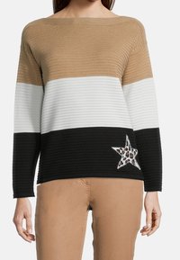 Sweter z dzianiny w poziome paski w kolorze beżowym, białym i czarnym. Posiada akcent w formie gwiazdy w panterkę na czarnej części. Fason z prążkowanej struktury.