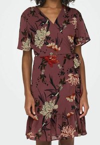 Vestido envolvente en color malva con estampado floral. Mangas cortas, escote en pico, cintura con lazo propio y dobladillo con volantes. Tejido ligero con una textura suave.