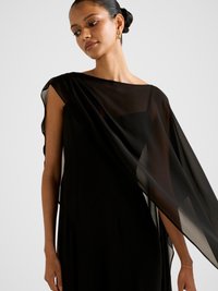 Černé večerní šaty s průsvitným překryvem přes jedno rameno, s přiléhavým živůtkem a měkkou texturovanou látkou.