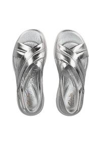 Sandalias plateadas metálicas con correas entrecruzadas, plantilla perforada, suela plana y detalle de cremallera en el lateral para facilitar su uso.