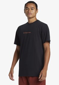 Black t-shirt made of cotton, featuring short sleeves, a round neck, and a small orange "Quiksilver" logo on the front.