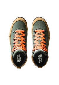 Buty wędrówkowe z zielonym materiałowym wierzchem, brązowymi zamszowymi akcentami, jaskrawymi pomarańczowymi sznurowadłami oraz gumową podeszwą z detalem logo na języku.