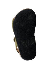 Suela de goma negra con patrón texturizado, correas verdes y acentos marrones. Presenta un diseño plano y un talón reforzado para mayor durabilidad.