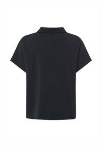 Polo shirt nero a maniche corte con colletto classico, vestibilità comoda e texture liscia. Design semplice e senza decorazioni con spallina posteriore.