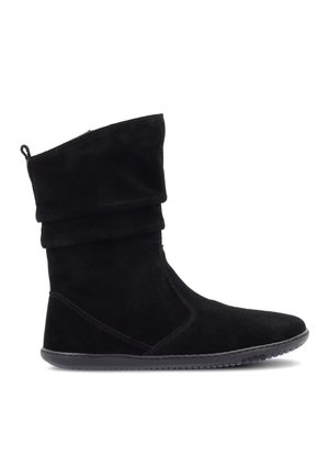 Stivale in camoscio nero a metà polpaccio con gambale morbido, punta arrotondata, suola piatta antiscivolo e linguetta posteriore.