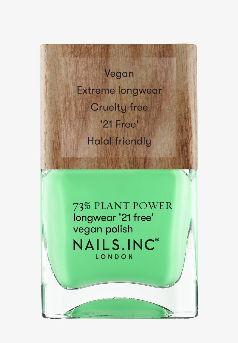 Grön vegansk nagellack i en klar glasflaska med ett trälock. Har etiketter för '73% växtkraft' och cruelty-free.