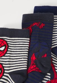 Tre par med marineblå og hvite striper med røde og svarte Spider-Man ansikts- og hånddesign stablet sammen.