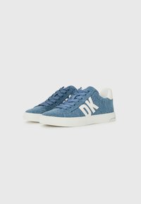 Blå denim sneakers med hvite gummisåler, med blå snøringer og en fremtredende hvit "DK"-logo på siden. Glatt tekstur, uformell design.