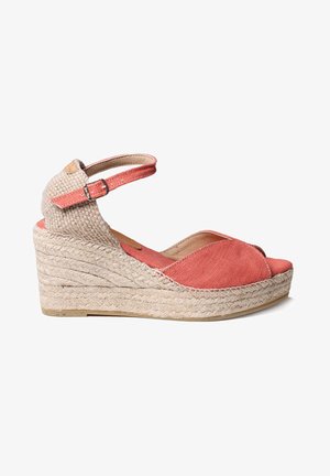 Koraljne wedge sandale s jute platformom, gornji dio od tkanine, otvoreni prsti i podesiva naramenica. Imaju teksturiranu tkaninu i suptilne šavove.