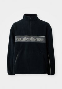 Sort fleece sweatoplevel med kvart-zip halsudskæring, lynlåslommer i siderne og et stort Quiksilver-logo tværs over brystet i grå.