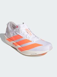 Biele bežecké topánky s jasne oranžovými akcentmi a tromi šikmými pruhmi. Majú ľahký sieťovinový zvršok a podrážku Lightstrike Pro.