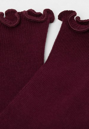 Burgundy ribbed fabric with a wavy, ruffled edge detail. The material appears soft with a textured surface, showcasing distinct ridges.