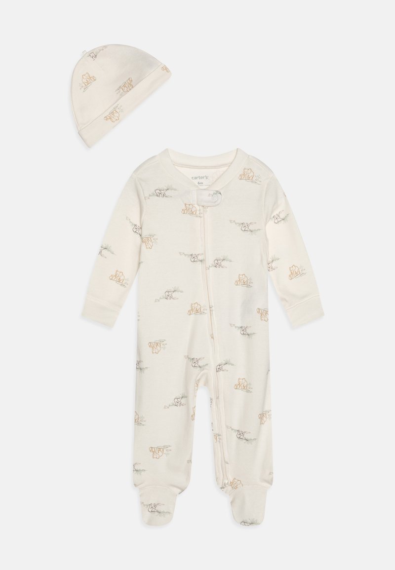 Hvit bomullsdrakt med lysebrune dyretrykk og en matchende hatt. Har glidelås foran og lukkede føtter. Myk og glatt tekstur.