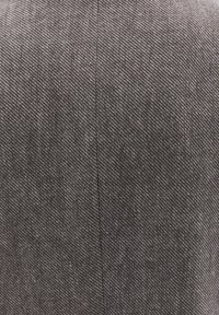 Harmaa kangas, jossa on hienovarainen herringbone-kuvio, joka ominaisuuksiltaan on sileä ja keskeltä kulkee pystysauma.