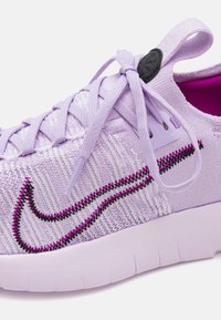 Helle lila Sneakers aus strukturiertem Material, gewebtem Design, mit schwarzen und pinken Nähakzenten sowie einem auffälligen Logo. Mit flexibler Sohle.