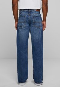 Lichtblauwe denim jeans met een losse pasvorm, met een hoge taille, twee achterzakken en een lichte vervaging voor een textuur-achtige uitstraling.