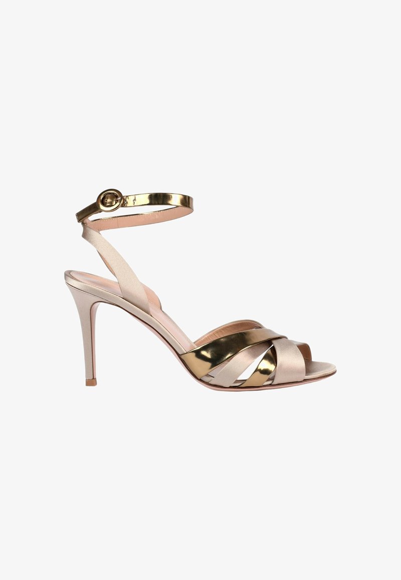 Sandale à talon haut avec brides croisées beige et or, bout ouvert, fine bride à la cheville et boucle dorée.