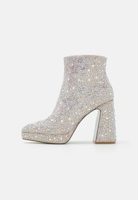 Glittering ankle boot with a rounded toe, covered in small iridescent gems, featuring a chunky, clear high heel and textured upper.