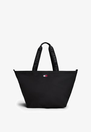 Czarna torba typu tote Tommy Jeans z szerokimi materiałowymi uchwytami, z napisem "Tommy Jeans" i małą naszywką z logo na środku z przodu.
