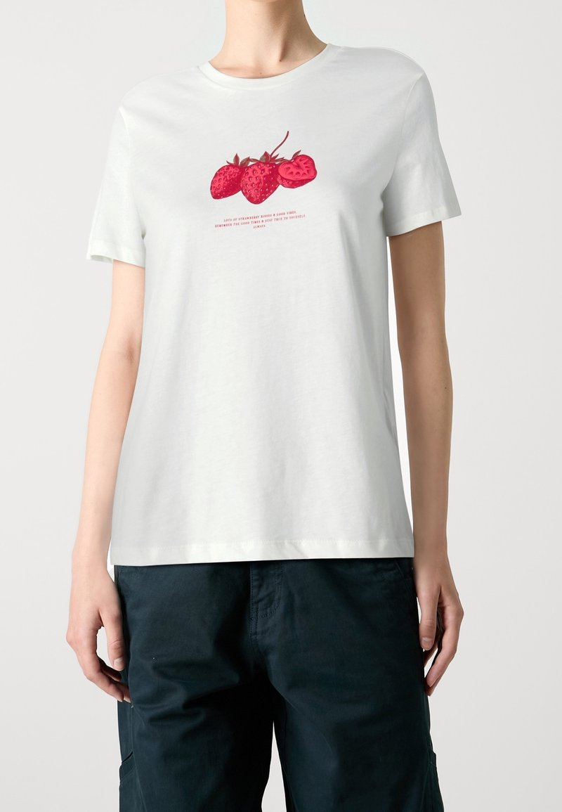 Hvid bomuld T-shirt med en rød jordbærgrafik i midten og tekst nedenunder. Korte ærmer, rund hals, afslappet pasform.