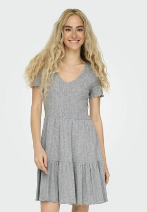 Grå klänning med kort ärm och V-ringning, texturerad tyg, åtsittande bodice och utsvängd, veckad kjol. Utsmyckning med scalloped fåll i botten.