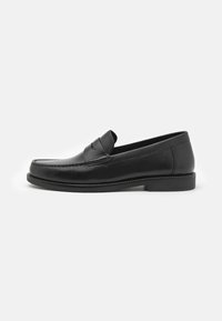 Schwarze Lederloafer mit abgerundetem Zehenbereich, genähten Details entlang der Oberseite und flacher Sohle. Elegante und glatte Textur.