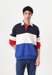 Farverig pullover med krave; har marineblå, cremefarvet, rød og blå vandrette striber; blødt bomuldsstof; ribbede manchetter og kant.