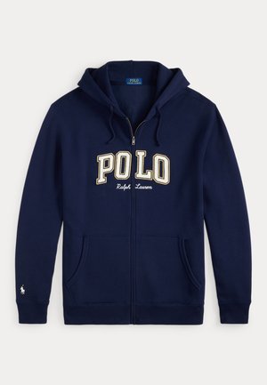 Mėlynas užtrauktukas džemperis, pagamintas iš medvilnės, su priekiu kengūros kišene. Pasižymi siuvinėtu "POLO" logotipu kreminės spalvos ir mažu jojiko emblemu ant rankovės.