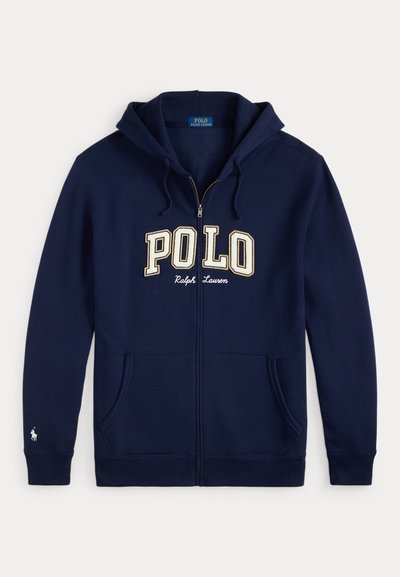 Navy zip-up hoodie i bomull med en framficka av typ kangaroo. Har en broderad "POLO"-logotyp i beige och en liten polo-spelare emblemet på ärmen.