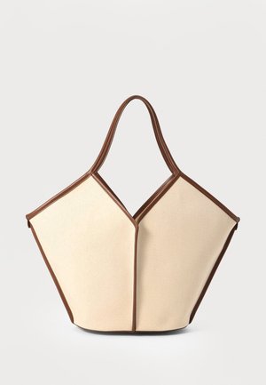 Sac en toile avec un corps crème et des accents en cuir marron. Le design présente une ouverture en V unique et deux poignées courbées.