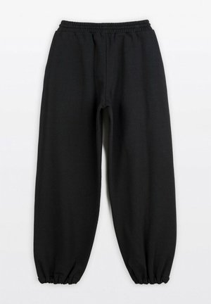 Czarne spodnie dresowe wykonane z miękkiego materiału, z elastycznym pasem i ściągaczami, o luźnym, prostym kroju bez widocznych wzorów.