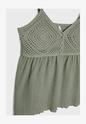 Zelena brezrokavna obleka ima teksturiran zgornji del z diamantskim kvačkanjem, sprednje gumbe in nabrano, ohlapno krilo.