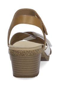 Bruine en witte wedge-sandalen met een kurkachtige zool, voorzien van meerdere banden en een gladde leren afwerking, met een gelaagd design.