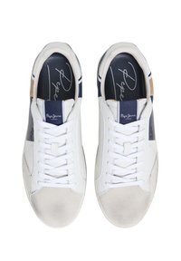 Zapatillas sintéticas blancas con acentos en navy y marrón claro, con textura suave, cierre de cordones en la parte delantera y logo en la plantilla.