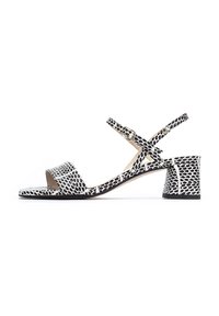 Las sandalias de tacón con estampado en blanco y negro cuentan con una amplia tira en la parte delantera, una correa en el tobillo con hebilla y un tacón chunky texturizado.