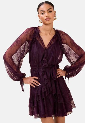 Lila Spitzenkleid mit langen, durchsichtigen Ärmeln, gerafftem Ausschnitt und mehrlagigem Rock. Verfügt über eine taillierte Taille mit Gürtel und ein zartes Blumenmuster.