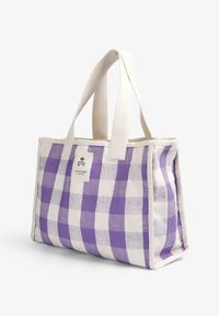 Bolso tote a cuadros morados y blancos con material de lona, asas crema y una etiqueta de logo en la parte frontal. Diseño resistente, tamaño mediano.