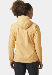 Chaqueta amarilla, ligera y con capucha; cuenta con puños elásticos y una textura suave y resistente al agua. Diseño sencillo y casual.